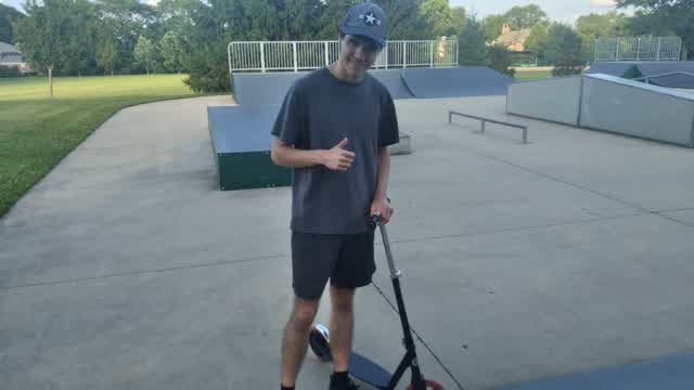 Riding a Scooter at a Skateboard Park